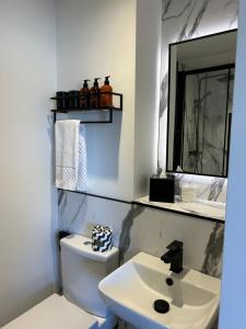 a white bathroom with a sink and a mirror at Nine King Street Seahouses room only accommodation in Seahouses
