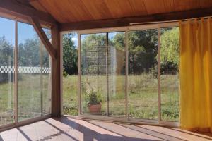 a screened in porch with windows and a potted plant at Gîtes et Camping Hameau Nouste Temps in Castelnau-Magnoac