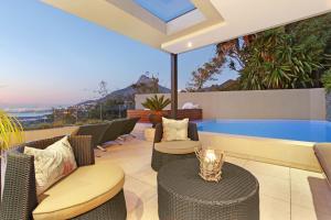 a patio with chairs and a swimming pool at Azamare Guest House in Cape Town