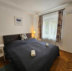 a bedroom with a large bed with two towels on it at Adri Apartman in Zalakaros