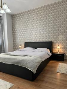 a bedroom with a large bed and a large wall at Ada's Luxury Apartment - Old City in Braşov
