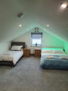 a bedroom with two beds and a window in it at Clydfan No 1 Trearddur Road in Trearddur