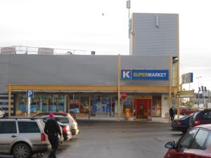 una gasolinera ksupermite con coches aparcados en un aparcamiento en Piriko Piccolo Apartment, en Rovaniemi