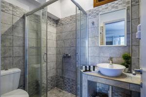 ein Bad mit einer Glasdusche und einem Waschbecken in der Unterkunft Sea View Studios in Skopelos