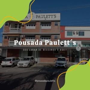 un bâtiment avec des voitures garées dans un parking dans l'établissement Pousada Paulett's - Hospedagem na Zona Norte de Ilhéus - Bahia, à Ilhéus