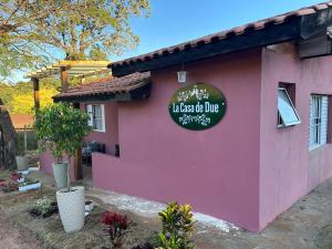 a pink house with a sign on it at La Casa de Due in Serra Negra