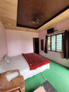 ランズドーンにあるRohini Village Homestayのベッドと椅子のある寝室
