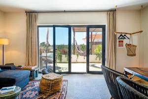 a living room with a couch and a sliding glass door at Viladraga - Casa da Adraga in Colares