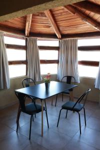 una mesa y sillas en una habitación con ventanas en Cabañas Tío Joe en San Antonio de Arredondo