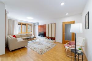 a living room with a couch and a table at Skenderpasina Skyline 2-bedroom apartment with balcony in Sarajevo