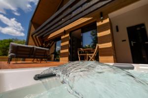 a bath tub filled with water in front of a house at True Cabin in Sovata