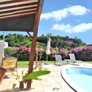 een patio met stoelen en een zwembad bij Villa d'une chambre avec piscine privee terrasse amenagee et wifi a Le Gosier a 1 km de la plage in Le Gosier