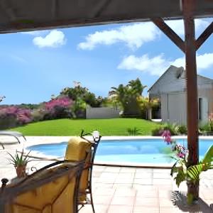 een patio met uitzicht op een zwembad bij Villa d'une chambre avec piscine privee terrasse amenagee et wifi a Le Gosier a 1 km de la plage in Le Gosier