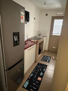 a small kitchen with a refrigerator and a sink at Departamento centro Quillota con estacionamiento in Quillota