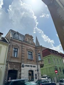 a building on a street with cars parked in front at Ada's Luxury Apartment - Old City in Braşov