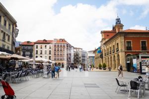 a city square with chairs and tables and buildings at Apartamento Rivero - Avilés in Avilés