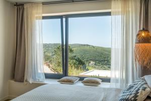 a bedroom with a large window with a view at Casa da Adraga in Colares
