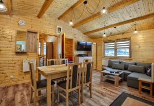 a kitchen and living room with a table and a couch at Domek Na Roztoczu in Kaczórki