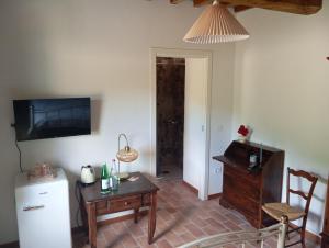 sala de estar con mesa y TV en la pared en Casale Regnano, en Lama