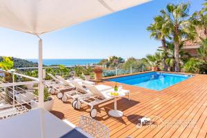 een zwembadterras met stoelen en een tafel en een zwembad bij Super Villa Oasis Fab Sea and Sitges View with Private Pool and Air Conditioning in Sitges