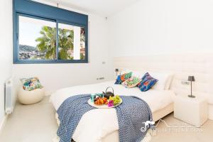 een slaapkamer met een bed en een dienblad met fruit erop bij Super Villa Oasis Fab Sea and Sitges View with Private Pool and Air Conditioning in Sitges