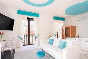 a living room with a white couch and a table at Babylon Luxury Suite & Apartments in Naples