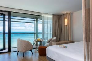a hotel room with a bed and a view of the ocean at Oceania Saint Malo in Saint Malo