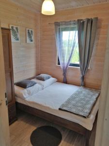 Duas camas num quarto com uma janela em SŁONECZNE DOMKI em Gąski