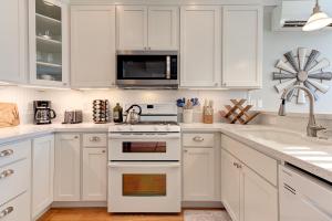 a white kitchen with white cabinets and a sink at Bigfoot by Seabrook Hospitality in Pacific Beach