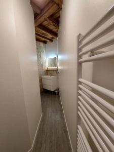 a hallway of a bathroom with a toilet and a sink at Au Jardin Secret proche Center Parcs in Pouançay