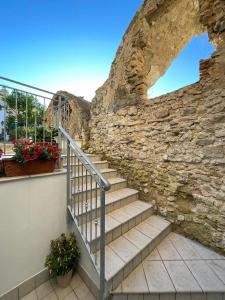 un muro di pietra con scale di fronte a un edificio di Il giardino dei sogni a Gaeta