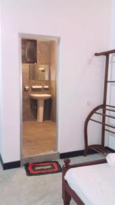 Habitación con baño con lavabo y espejo. en Yunal's Place, en Matara