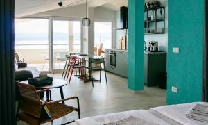 a living room with a kitchen and a table with chairs at holiday by the sea in Marusici 