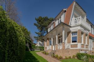 una grande casa bianca con un mattone di Villa-Sabbia a Koksijde