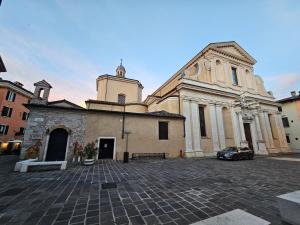 Un edificio con una iglesia con un coche aparcado delante. en Casa di Maggio - by tourquoisevea, en Desenzano del Garda