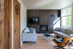 un soggiorno con divano e camino di Villa-Sabbia a Koksijde