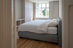 una camera da letto con un letto grande con una finestra di Villa-Sabbia a Koksijde