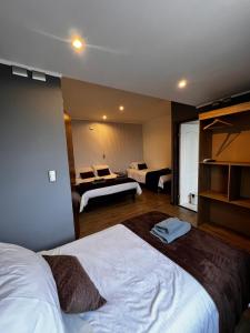 een hotelkamer met 2 bedden en een kamer met 2 bedden bij Hotel Mackenna in Osorno