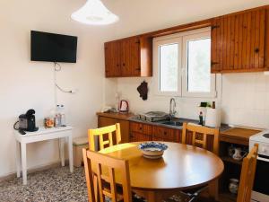 een keuken met een houten tafel en een eetkamer bij Rita's Beachfront House in Kampos Paros