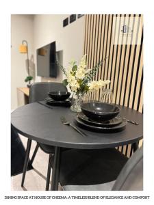 uma mesa com dois pratos e um vaso de flores em Flat 120 Luxury meets comfort em Beeston Hill