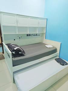 ein weißes Bett in einem Zimmer mit Aufschriften darauf in der Unterkunft perdana homestay in Ipoh