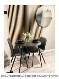 uma mesa de jantar preta com cadeiras e um espelho em Flat 120 Luxury meets comfort em Beeston Hill