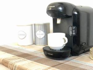 een koffiezetapparaat met een kopje op een tafel bij Rita's Beachfront House in Kampos Paros