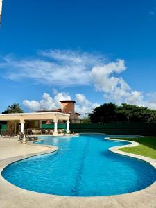 a pool with blue water in front of a building at AllMar Flats - Apartamentos frente mar - Beach Village in Fortaleza