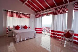 a bedroom with a bed with red and white curtains at RedHill Kandy in Kandy