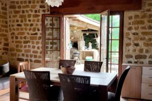 a dining room with a table and chairs and a window at Gîtes et Camping Hameau Nouste Temps in Castelnau-Magnoac