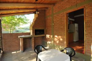 a patio with a white table and chairs on a brick wall at Bosque Encantado Cabañas in Villa Icho Cruz