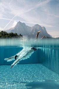 uma pessoa a nadar numa massa de água em Hotel Alpenflora em Castelrotto