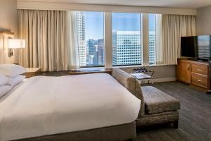 セントルイスにあるヒルトン セント ルイス アット ザ ボールパークの大きなベッドと大きな窓が備わるホテルルームです。