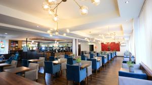 a dining room with blue chairs and tables at Motel Plus Berlin in Berlin
